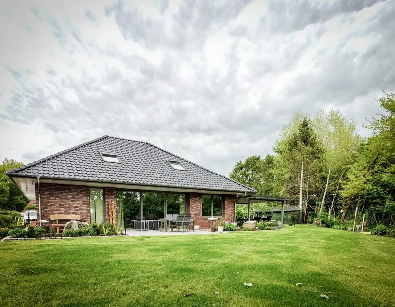 Neubau Haus R in Helmighausen, Backstein-Bungalow mit Walmdach und Rasenfläche